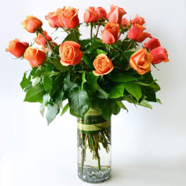 Orange roses arranged in a clear glass vase