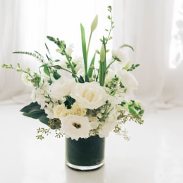 White floral arrangement in a dark glass vase