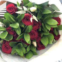 Bouquet of red roses with green foliage and white buds