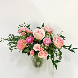 Pink and peach roses with small blooms in a clear glass vase