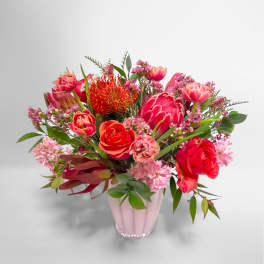Pink and red mixed bouquet in a pale pink vase