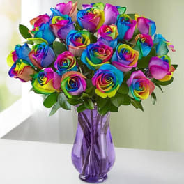 Bouquet of rainbow-colored roses in a purple glass vase