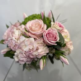 Pink roses and pale hydrangeas in a hand-tied bouquet