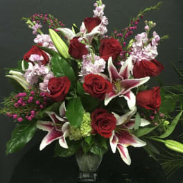 Red roses and pink lilies arranged in a clear vase