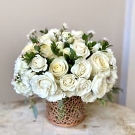 White rose bouquet in a decorative copper vase