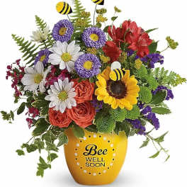 Colorful bouquet in a yellow pot with bee decorations