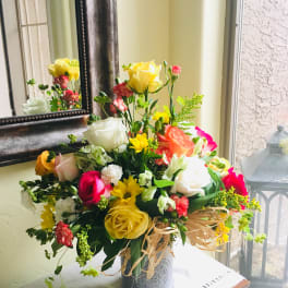 Colorful mixed flower arrangement in a metal vase on a table