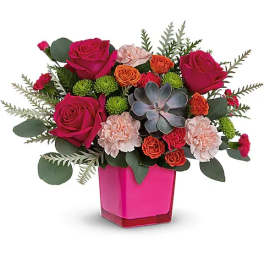 Pink and orange floral arrangement in a bright pink vase
