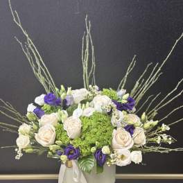 Bouquet of cream and purple roses in a white vase