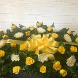 Yellow roses and white spider mums arranged with a yellow ribbon bow