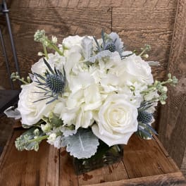 White roses and hydrangeas in a square glass vase