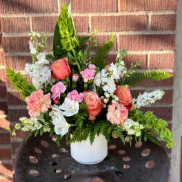 Pink and white floral arrangement in a white vase
