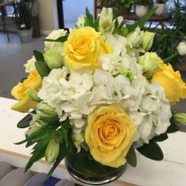 Yellow roses and white hydrangeas in a glass vase