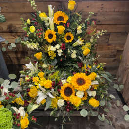 Large yellow and white floral arrangement with sunflowers and roses