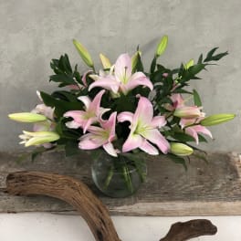 Pink lilies arranged in a clear glass vase