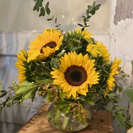 Sunflower arrangement in a round glass vase
