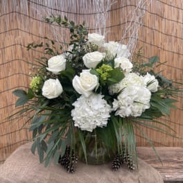 White roses and hydrangeas arranged in a glass vase