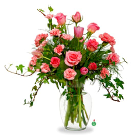 Pink roses and carnations arranged in a clear glass vase
