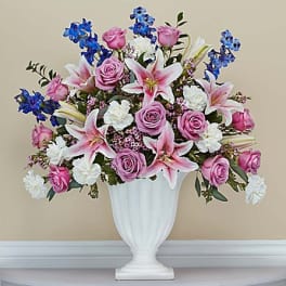 Pink roses and lilies arranged in a white vase