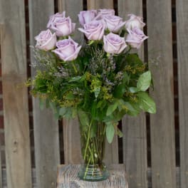 Lavender roses arranged in a clear glass vase