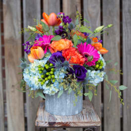 Colorful mixed bouquet in a rustic metal container