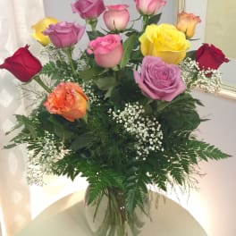 Mixed roses in a clear glass vase with baby's breath