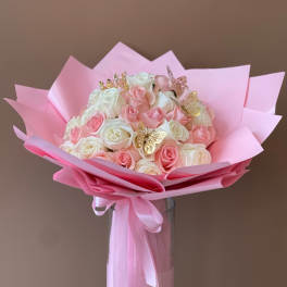 Pink and white rose bouquet wrapped in pink paper with butterfly picks