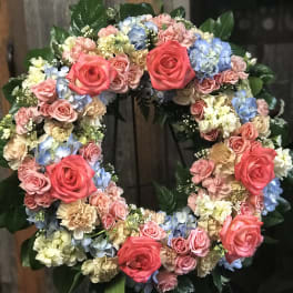 Circular floral wreath with pink roses and pastel hydrangeas