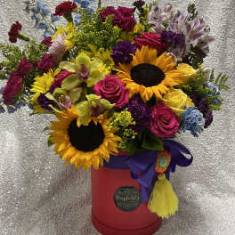 Mixed bouquet with sunflowers, roses, orchids, and alstroemeria in a red hatbox