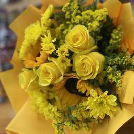 Yellow rose and chrysanthemum bouquet wrapped in yellow paper