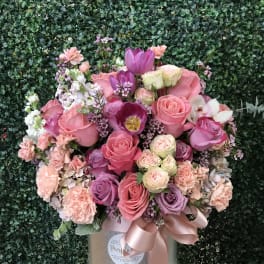 Pink and purple rose bouquet in a silver box with a satin ribbon