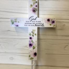 Floral cross sign with a sympathy message on a stake