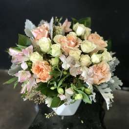 Peach and cream rose bouquet in a white vase