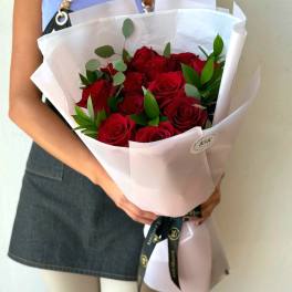 Bouquet of red roses wrapped in white paper