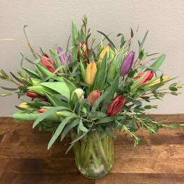 Bouquet of multicolored tulips in a clear glass vase