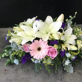 Low floral arrangement with white lilies, pink gerbera daisy, and pink roses