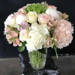 Pastel bouquet of roses and hydrangeas in a clear glass vase