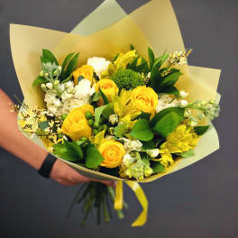 Yellow roses and white flowers in pale wrapping paper