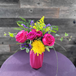 Pink roses and a yellow chrysanthemum in a pink vase