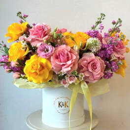 Bouquet of pink and yellow roses in a white hat box
