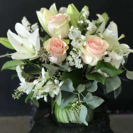 Bouquet of pale pink roses and white lilies with greenery