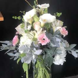 White calla lilies and pink gerbera daisies in a glass vase