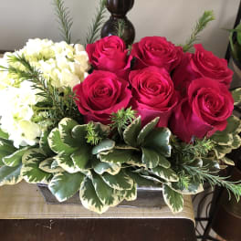 Pink roses and white hydrangeas in a low rectangular container