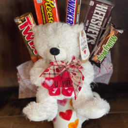 Teddy bear gift arrangement with candy bars in a heart-patterned cup