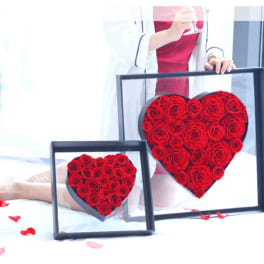 Two heart-shaped rose arrangements in black frames, one large and one small