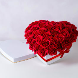 Heart-shaped box of red roses with a matching lid beside it