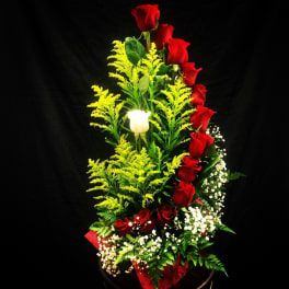 Red roses and a white rose in a tall floral arrangement