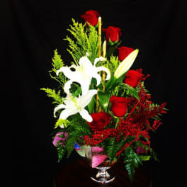 Red roses and white lilies in a clear glass vase