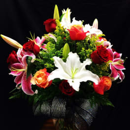 Bouquet of red roses and white lilies with pink lilies in a vase