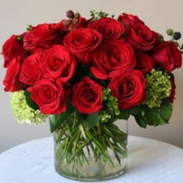 Red roses arranged in a clear glass vase